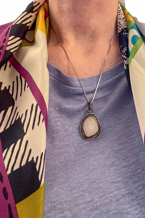 Natural white crystal pendant on model with scarf