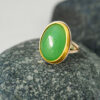 SC012 Chrysoprase Cocktail Ring web 1x1 Gold cocktail ring with green chrysoprase gemstone resting on a grey stone