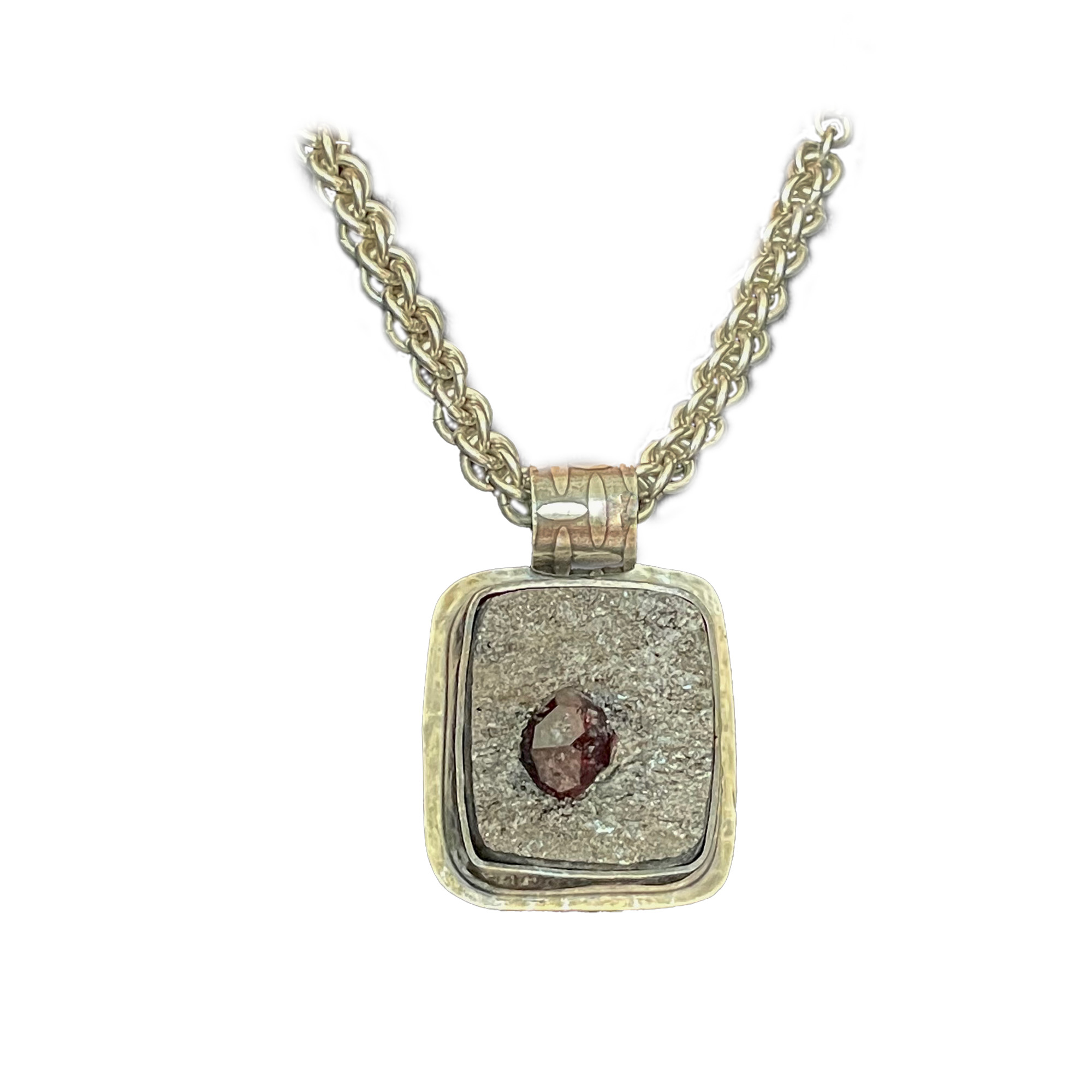 Raw Faceted garnet gemstone emerging from bed of sparkly schist matrix