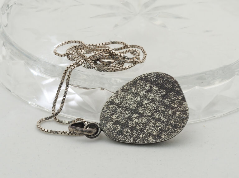 silver pendant necklace with an oxidized patina