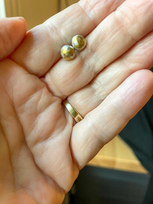 Fortune's Daughter Golden stud earrings in hand