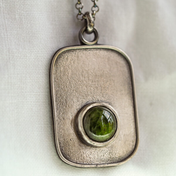 Silver dog tag necklace with green gemstone