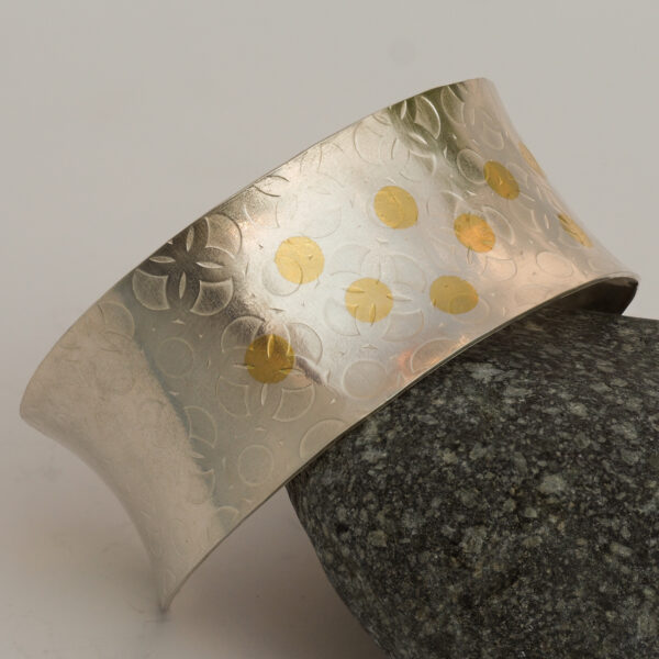 wide silver cuff bracelet with tooled pattern and gold dots