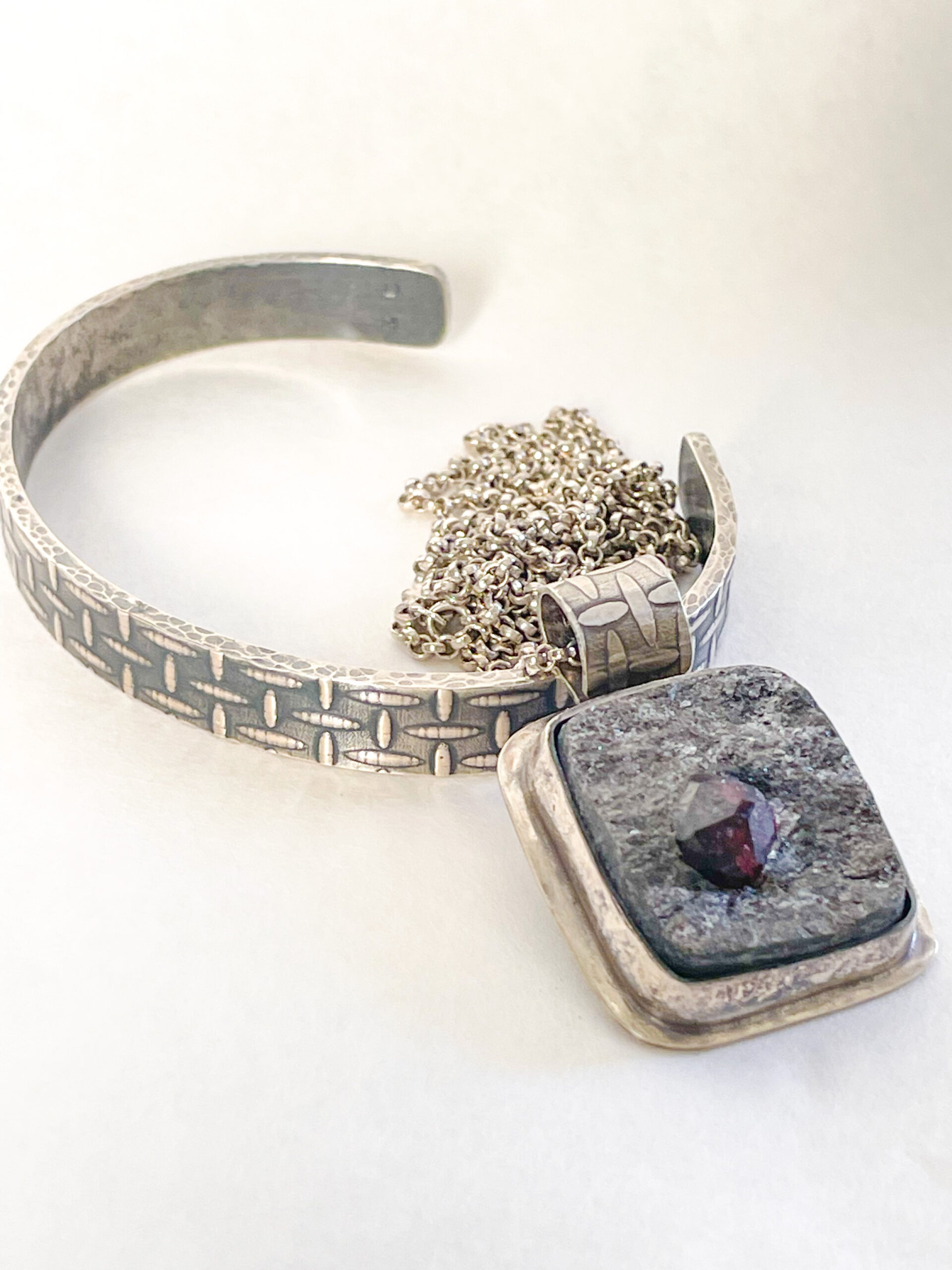 Red garnet in schist square pendant and patterned silver cuff bracelet