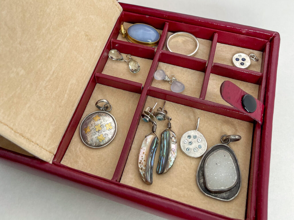 Red Travel Case with bento box interior filled with artisan jewelry
